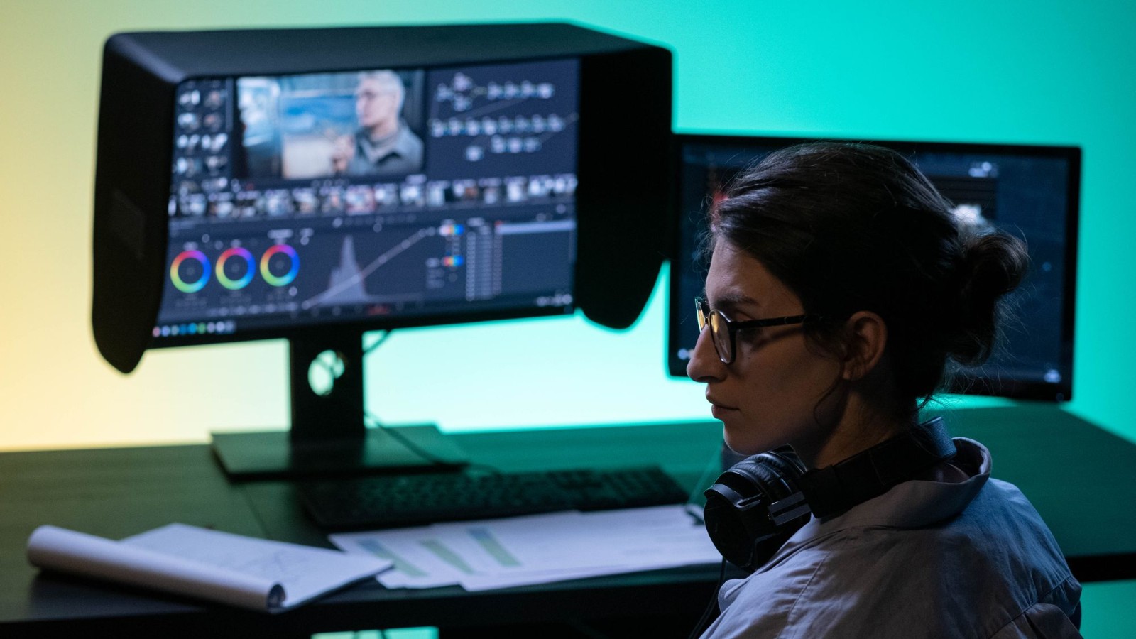 Колорист за работой у монитора с цветовыми колёсами и нодами в DaVinci Resolve